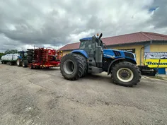 Hatalmas New Holland traktor és mezőgazdasági gépek a kisújszállási Kovi Autó Shop gumiszerviz előtt - 2025. október 1.